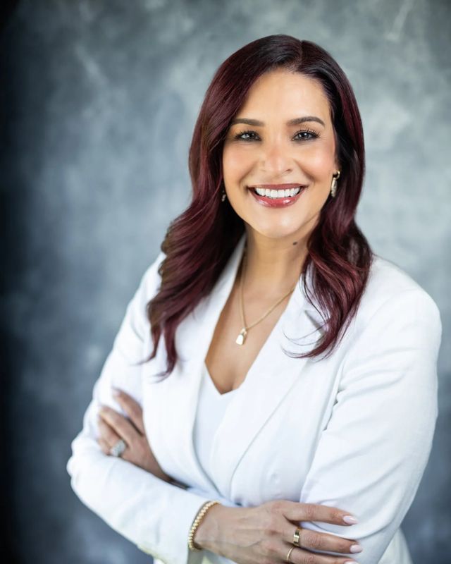 Studio headshot, white blazer, gray backdrop
