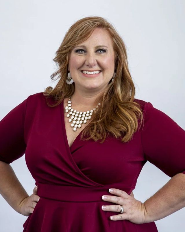 Studio headshot, burgundy dress, white backdrop