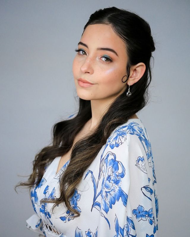 Actor headshot, floral top, gray backdrop
