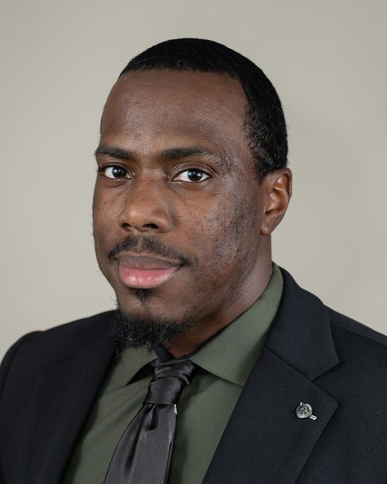 Studio headshot, olive shirt, warm gray backdrop